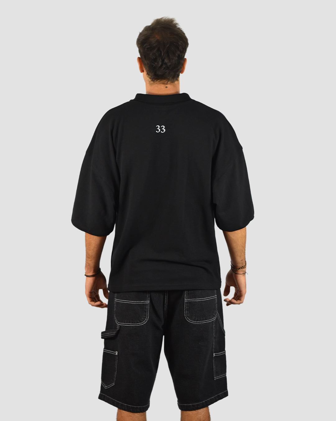 Detalle bordado polera piqué negra Lomvok - acabado artesanal premium